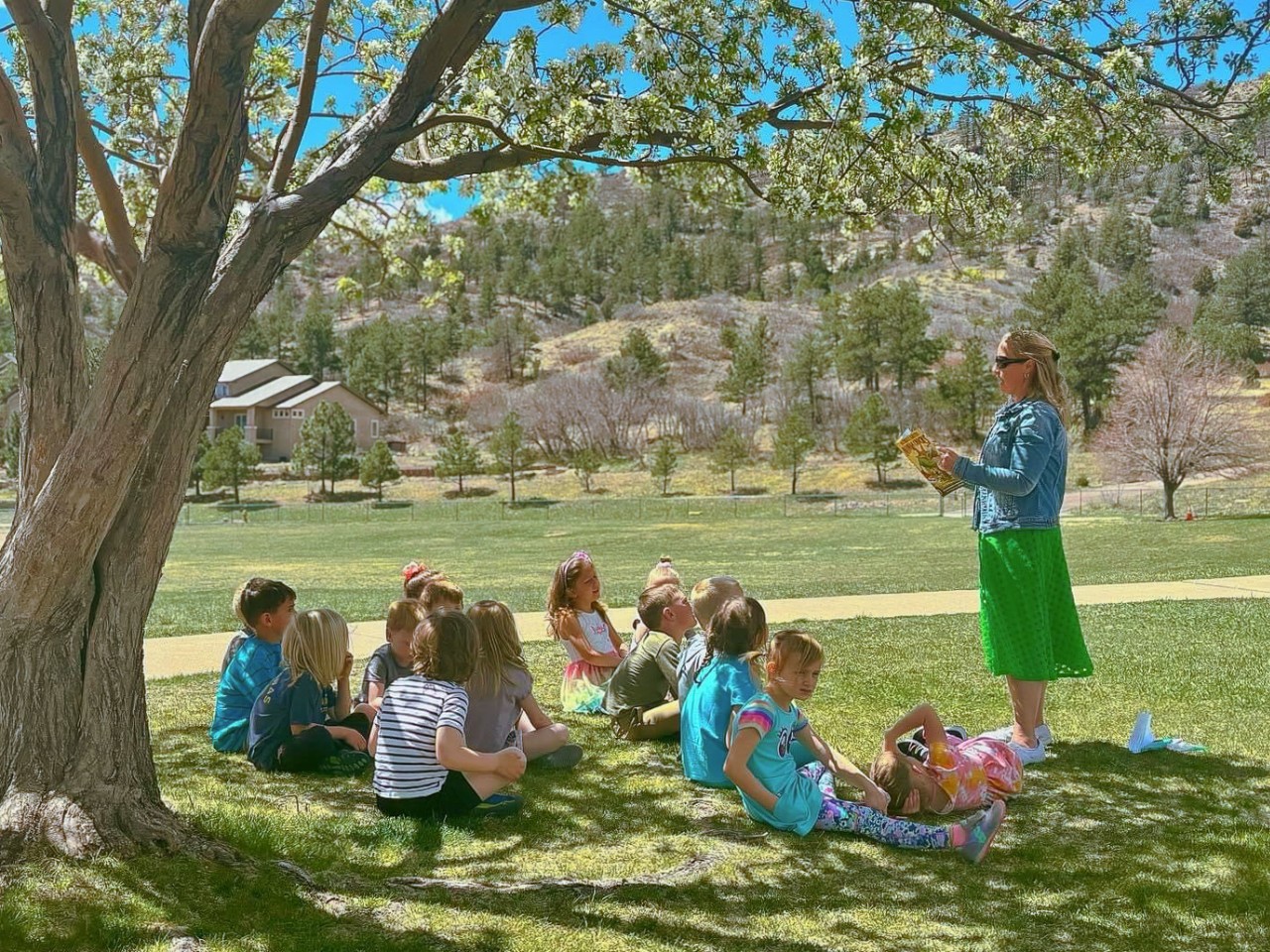 A teacher reading to their class outside